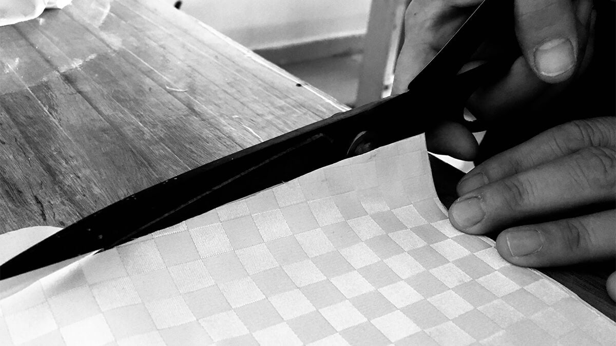 designer cutting a piano cloth fabric